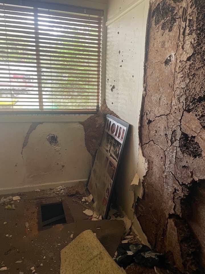 Wall and skirting damage in a room corner near a window